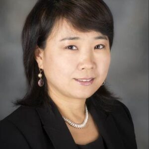 Professional portrait of a woman with short hair in business attire.